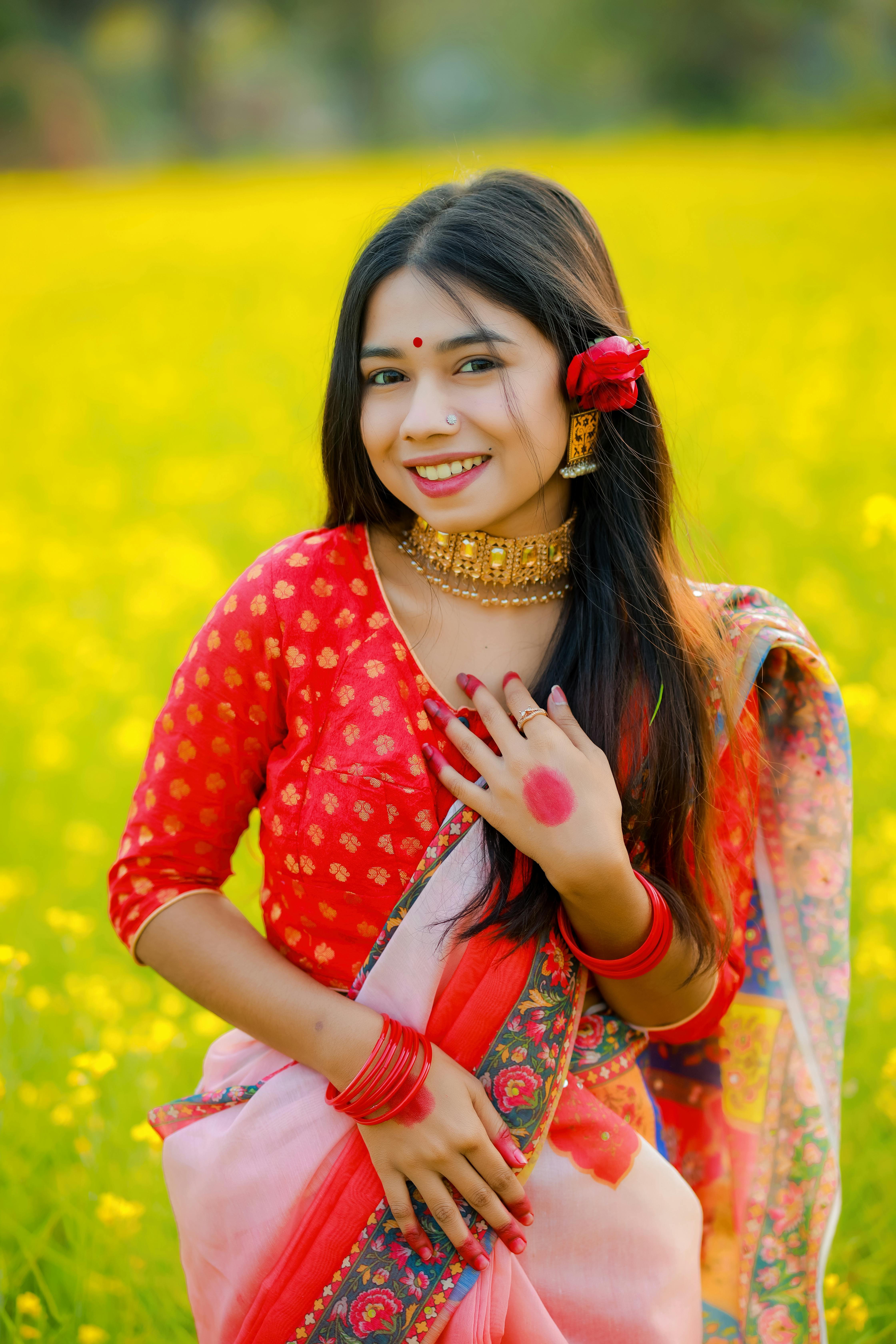 A South Asian woman in vibrant traditional attire posing in a lush flower field. Perfect for cultural and lifestyle themes.